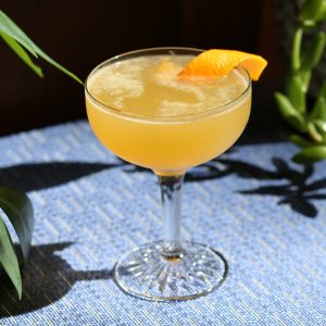 autumnal apple brandy sour served up in a coupe with a citrus twist
