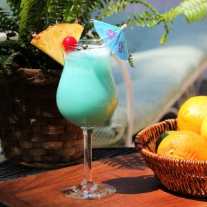blue hawaiian with a pineapple wedge, cherry, and a cocktail umbrella